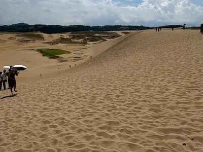 砂丘を歩く人々と広がる砂の風景