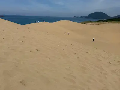 砂丘と海の風景、遠くに山が見える。