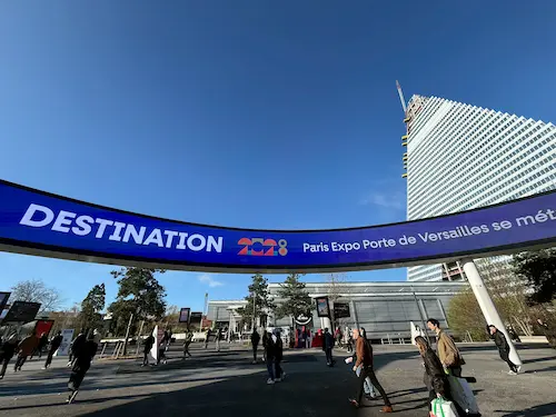パリ・エキスポ・ポルト・ド・ヴェルサイユの入口にある「DESTINATION 2023」の看板と訪問者